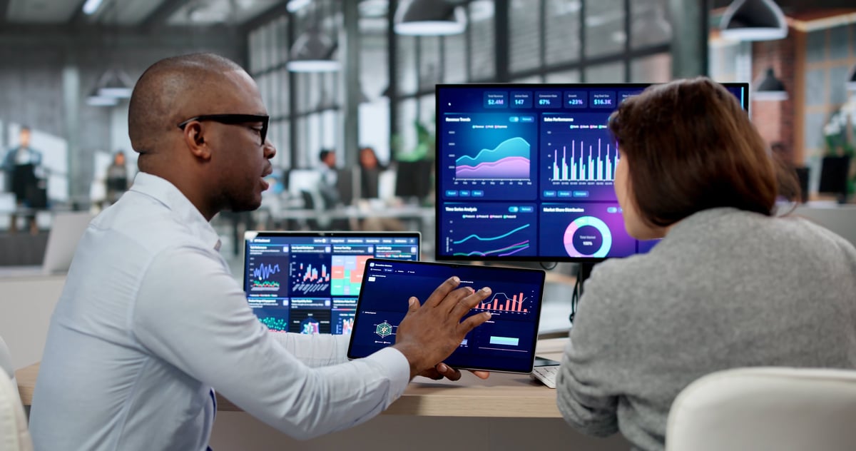 Business analyst and marketing coach examining KPI dashboards